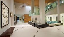 Interior of building lobby with staircase, elevators, couches and decor